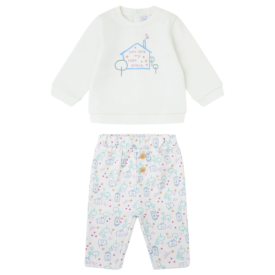 Conjunto de roupa para bebé com camisola branca e calças estampadas com casas e árvores.