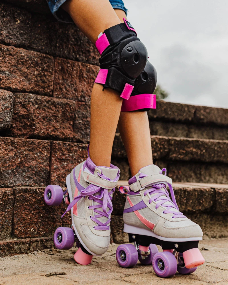 Patins de rodas cor-de-rosa e lilás com joelheiras pretas e rosa