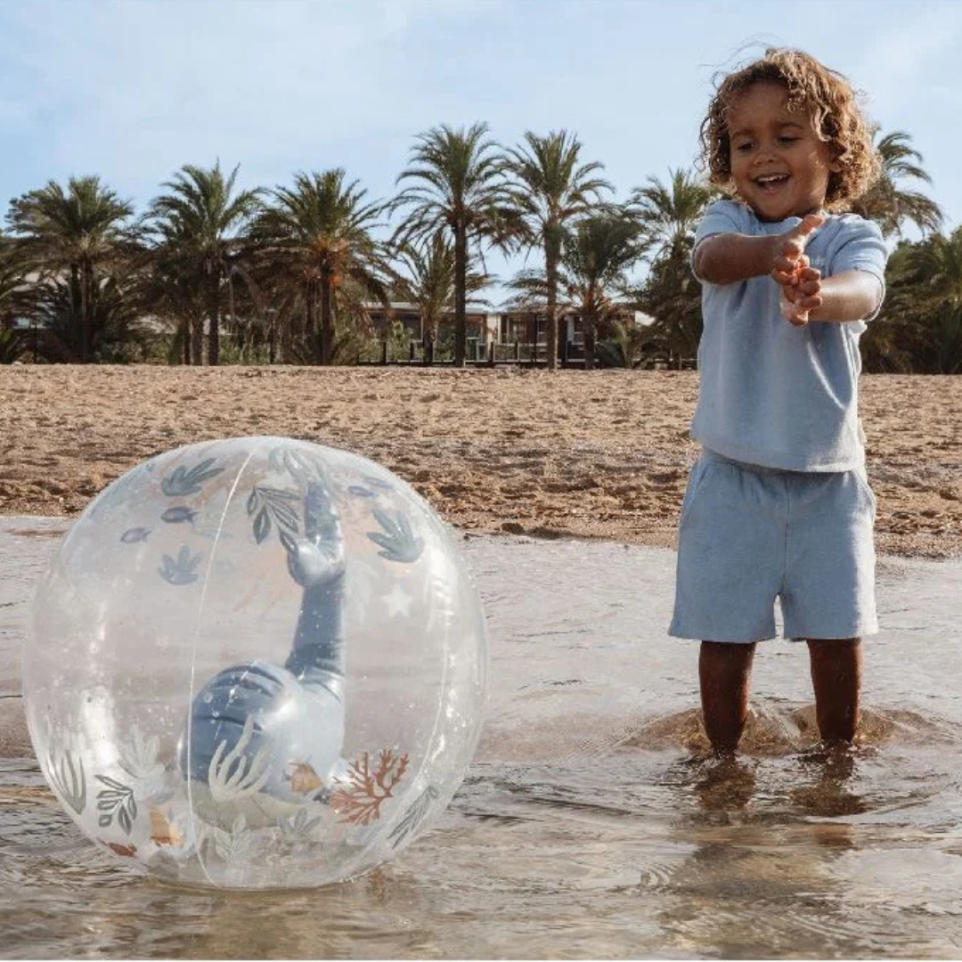 Criança brincando na água com bola insuflável transparente decorada