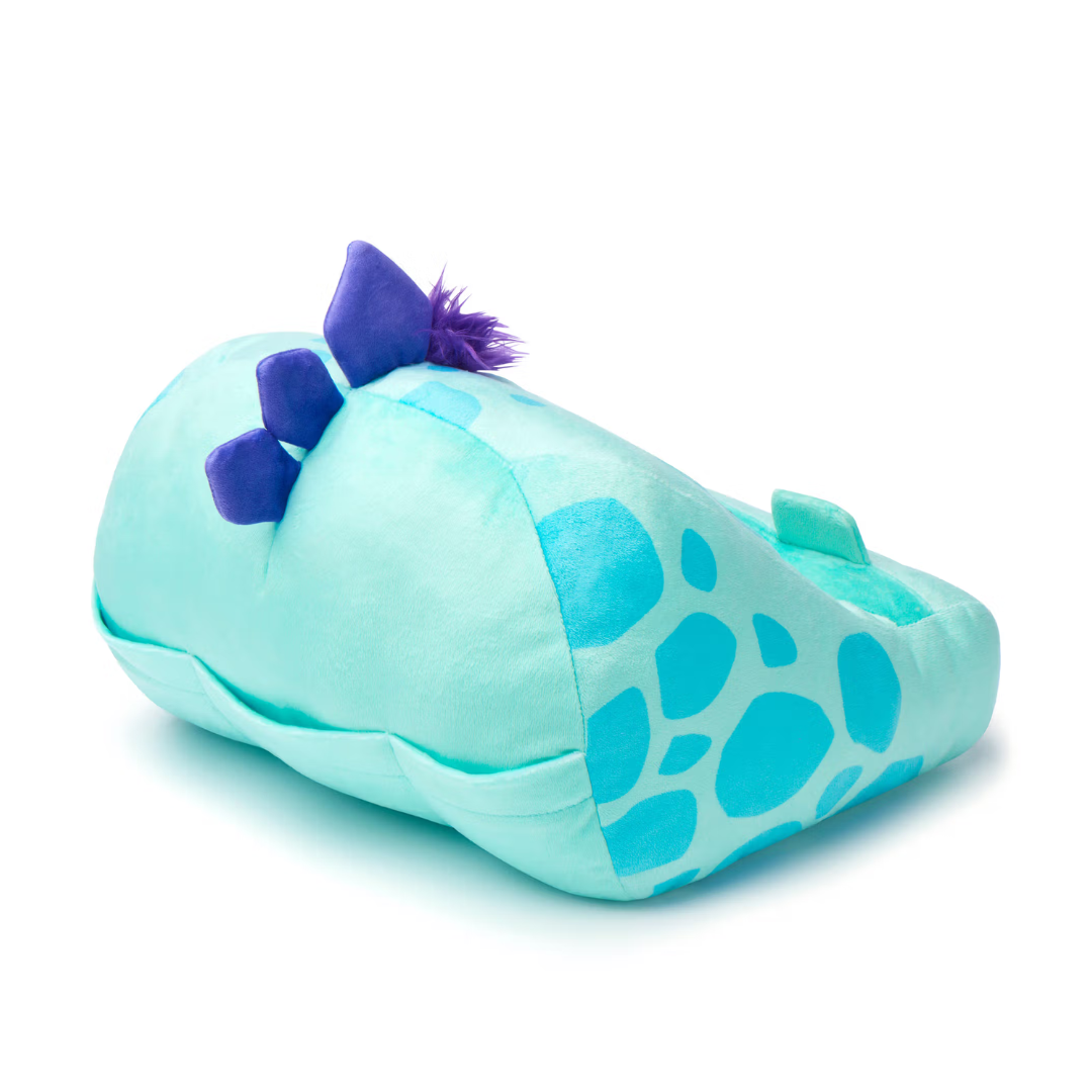 Pantufa macia em forma de dinossauro azul claro com manchas azuis e cristas roxas.