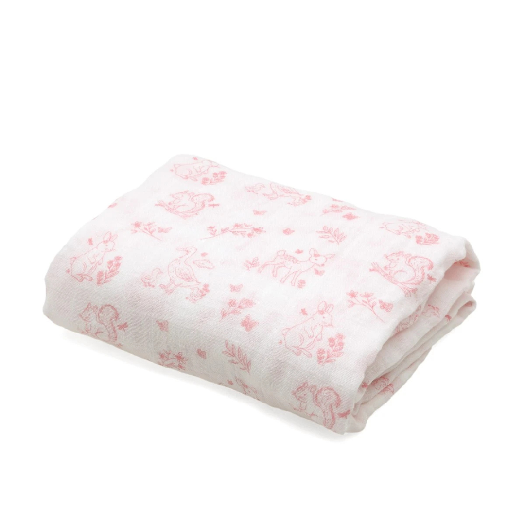 Cobertor branco com estampado rosa de animais e plantas dobrado