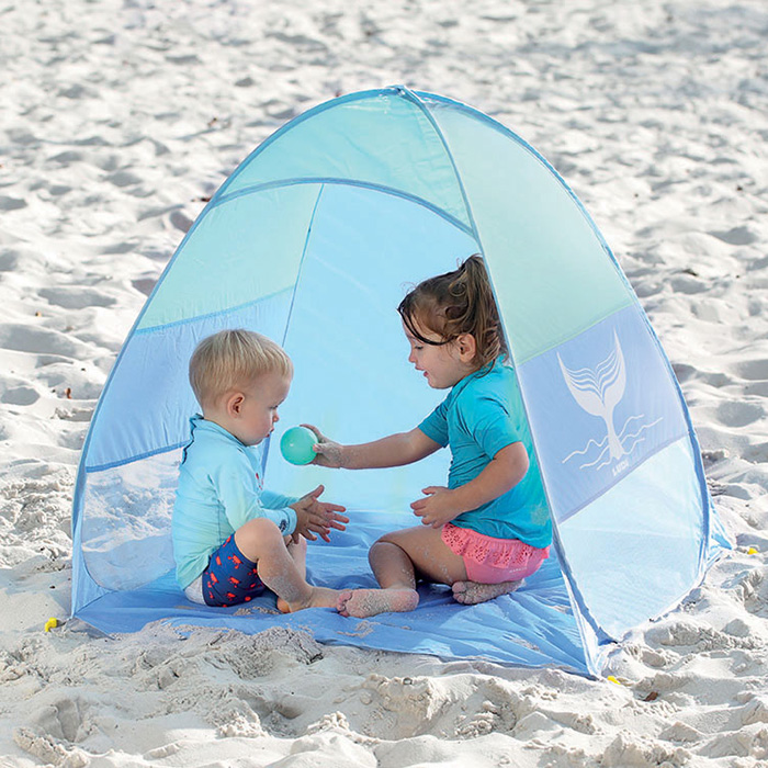 Tenda de praia azul com crianças sentadas na areia