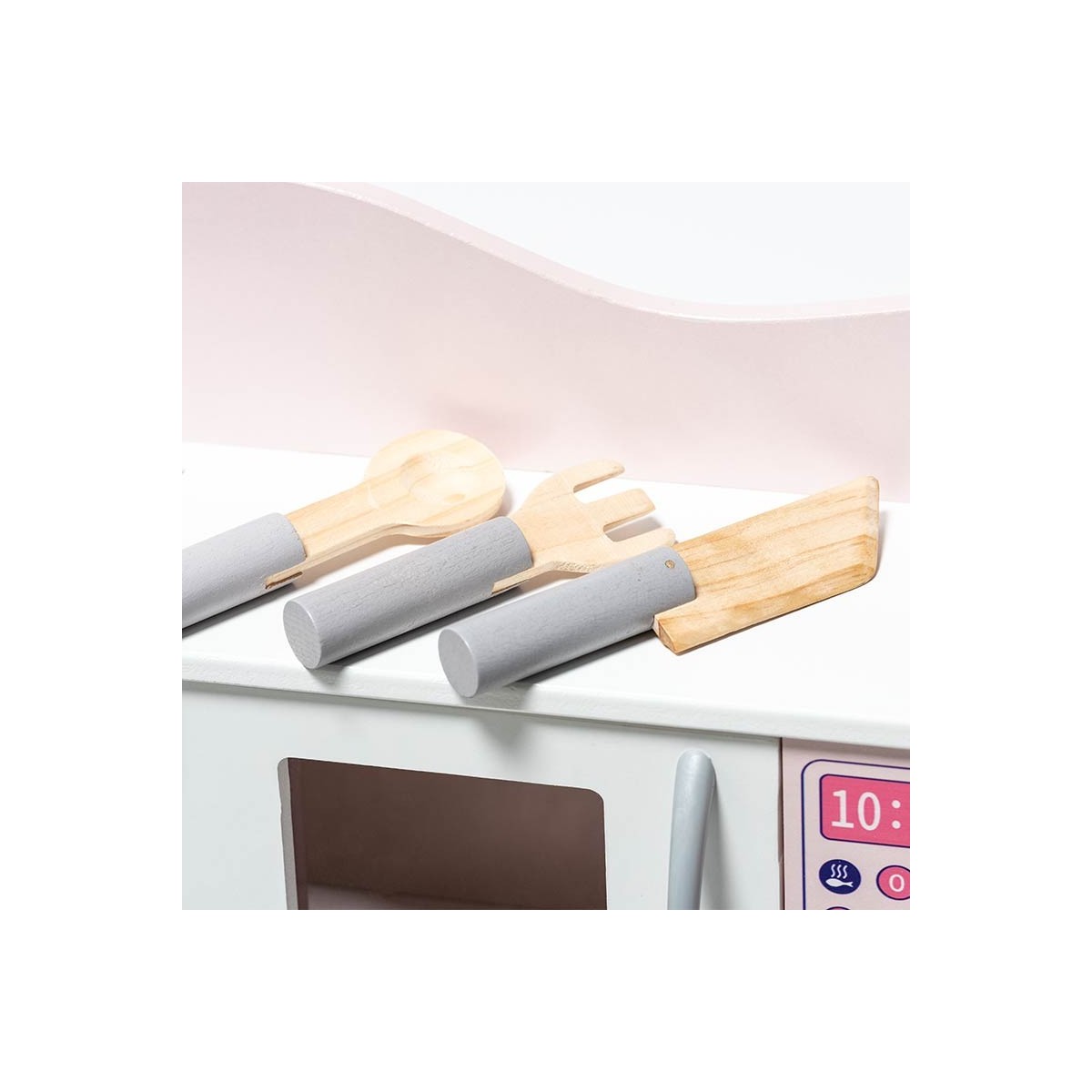 Utensílios de cozinha de madeira e silicone cinza sobre eletrodoméstico branco com visor rosa