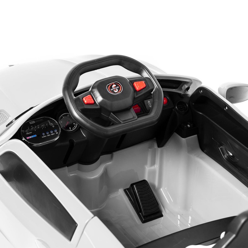 Interior de carro elétrico infantil branco e preto com volante e pedais