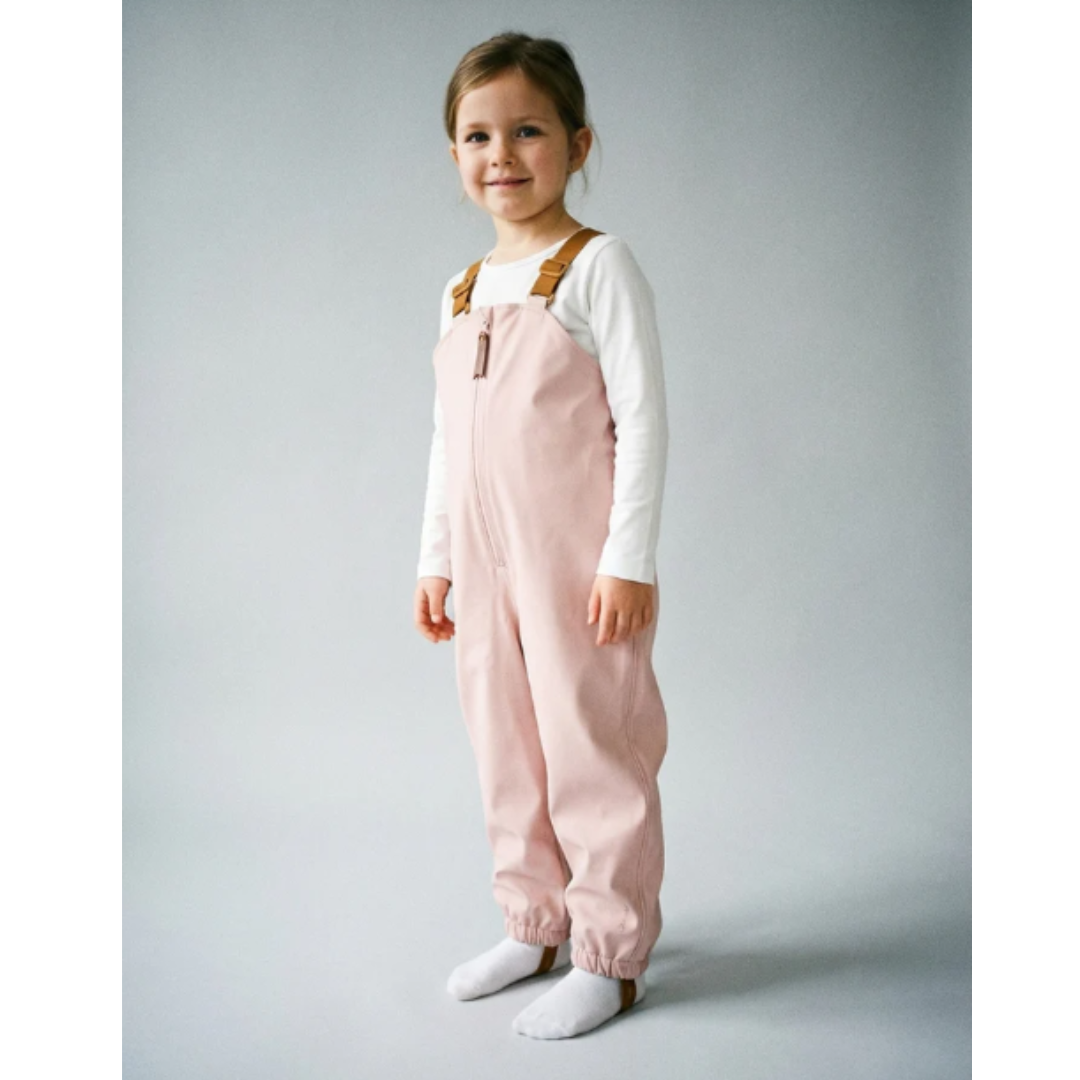 Criança com macacão rosa e camisa branca