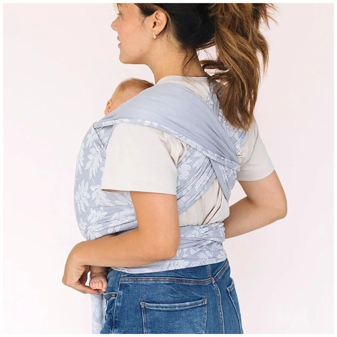 Mulher a usar porta-bebé azul claro com padrão floral branco