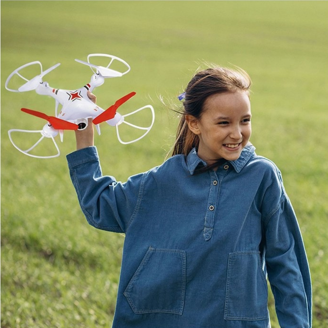 Menina com drone branco de hélices vermelhas ao ar livre