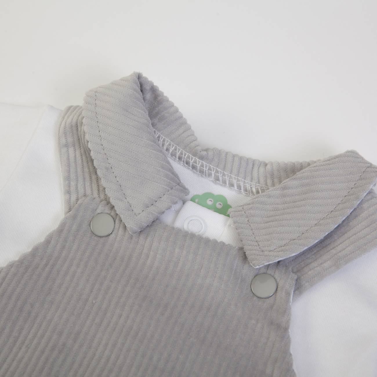 Conjunto de roupa de bebé com camisola branca e jardineira cinzenta de veludo cotelê