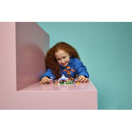 Peças de construção coloridas com figuras e dragão sobre superfície cor-de-rosa