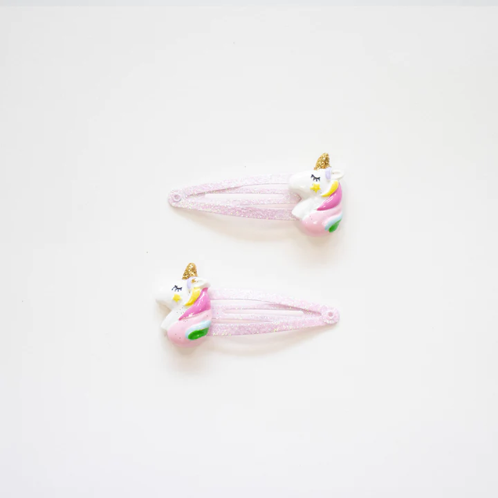 Par de molas de cabelo rosa com unicórnios coloridos em fundo branco