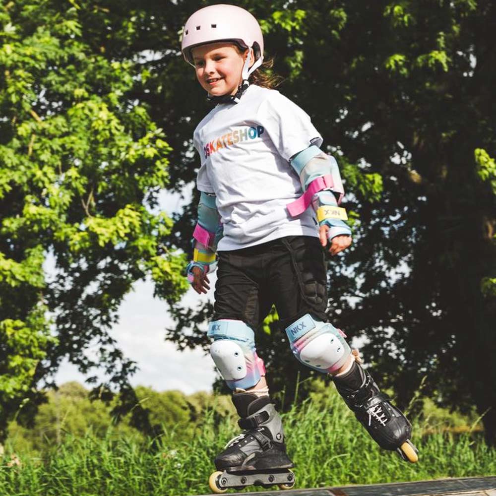Criança a andar de patins em linha com equipamento de proteção em parque exterior