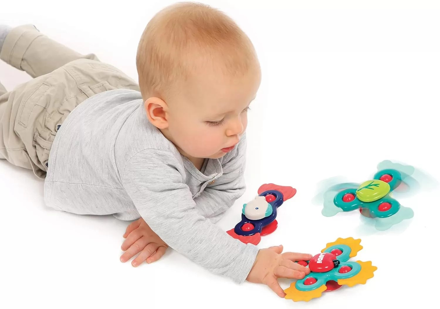Criança brinca com brinquedos coloridos em fundo branco