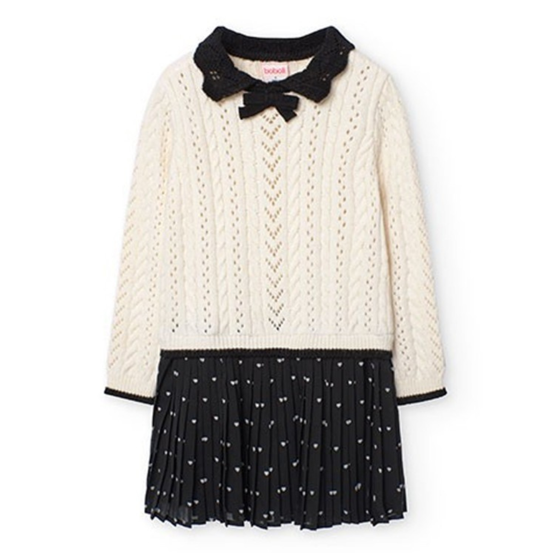 Vestido de criança creme e preto com padrão torcido e corações brancos.