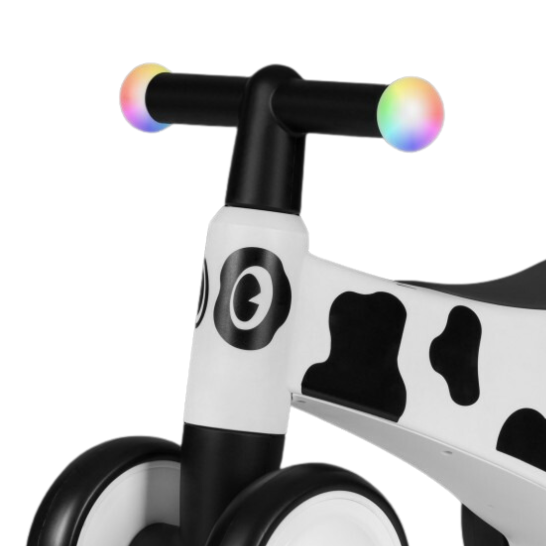 Bicicleta de equilíbrio infantil branca e preta com guiador colorido e design de vaca