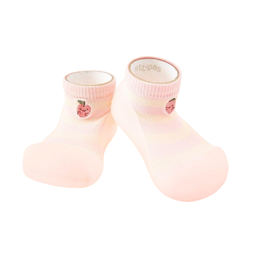 Sapatos de bebé cor de rosa com sola em borracha clara e desenho de maçã.
