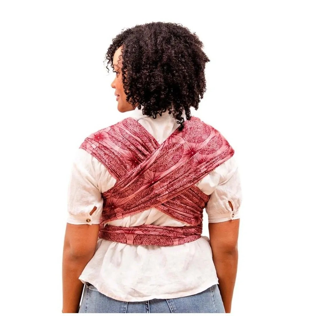 Mulher vista de costas com faixa de tecido vermelho com padrão nas costas sobre camisa branca