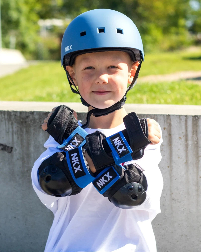 Criança com capacete azul e proteções pretas e azuis NIX ao ar livre