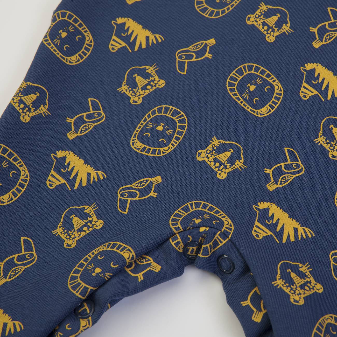 Tecido azul com estampado amarelo de animais e botões de pressão pretos