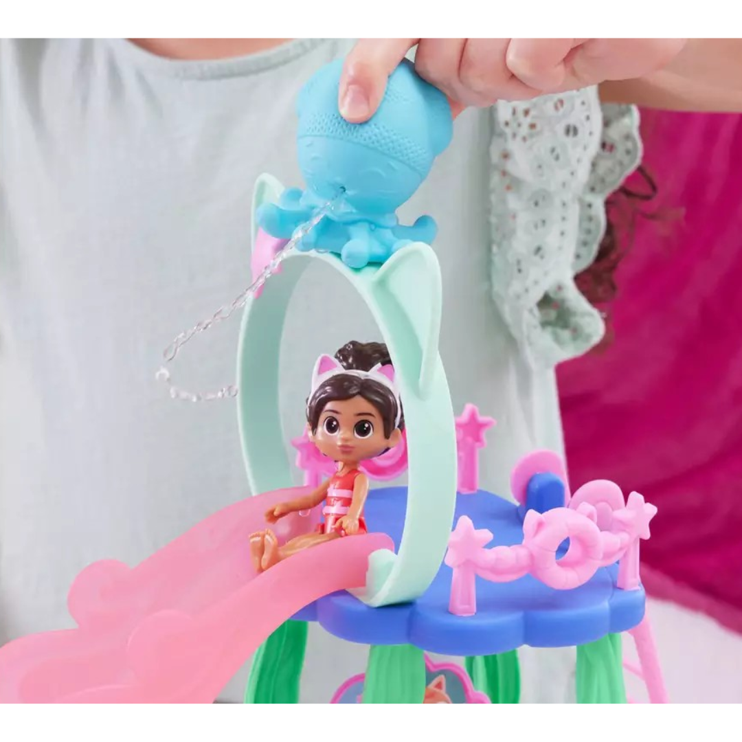 Brinquedo infantil com boneca sentada num escorrega e acessório em forma de polvo azul.