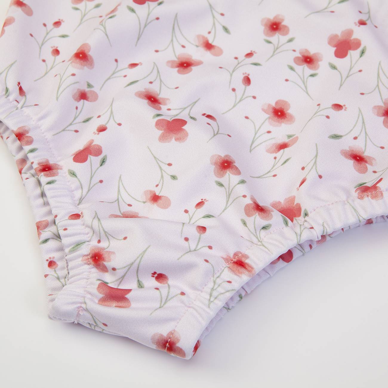 Roupa interior feminina com padrão floral vermelho e rosa sobre fundo branco