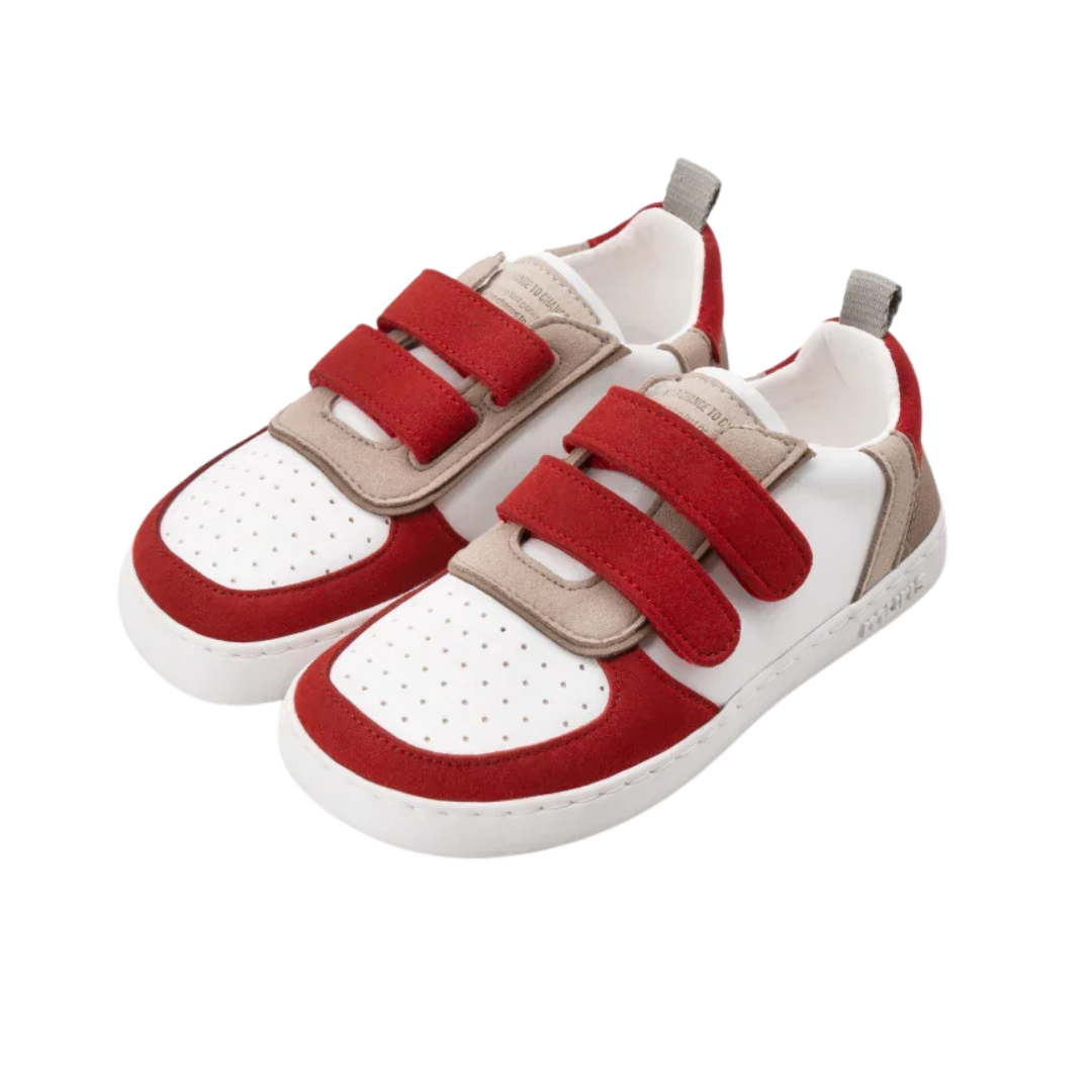 Sapatilhas infantis brancas com detalhes vermelhos e bege e fechos de velcro.