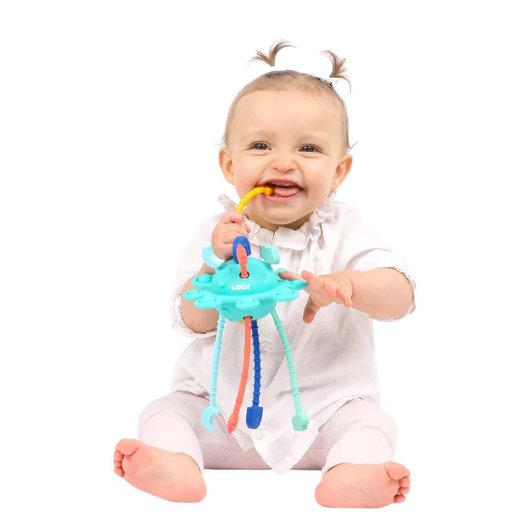 Bebé a segurar brinquedo colorido com várias pernas e anel amarelo