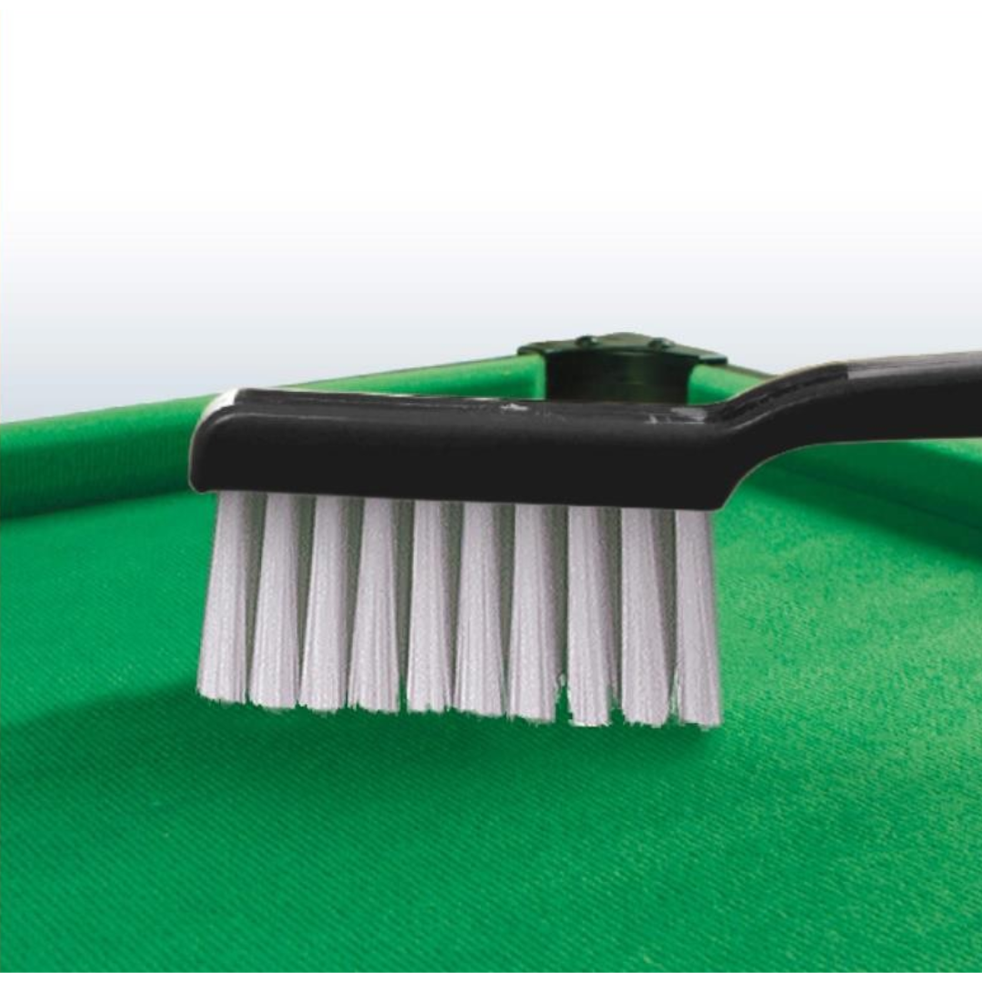 Escova de limpeza com cabo preto e cerdas brancas sobre superfície verde texturada