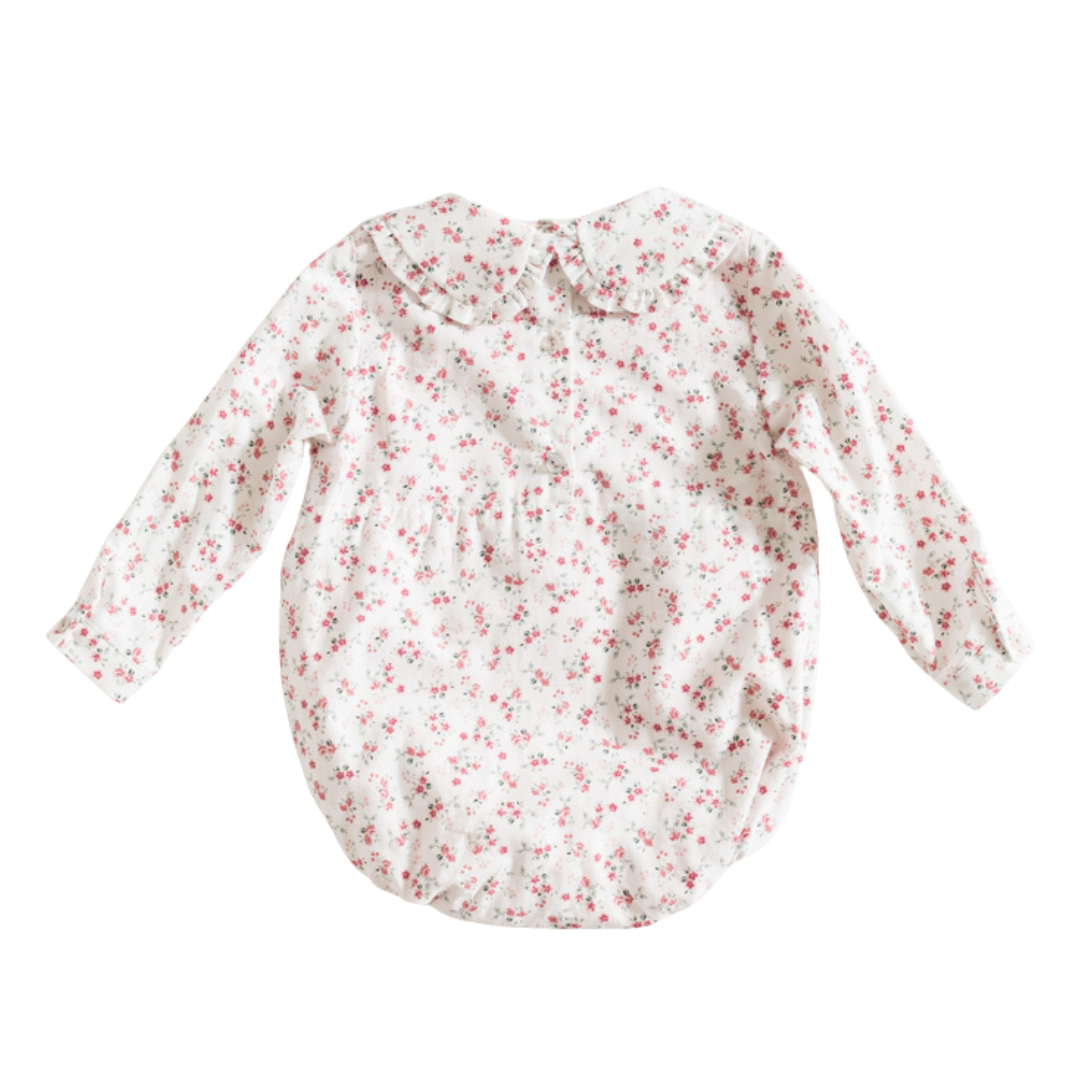 Macacão branco com flores pequenas cor-de-rosa e gola com folhos