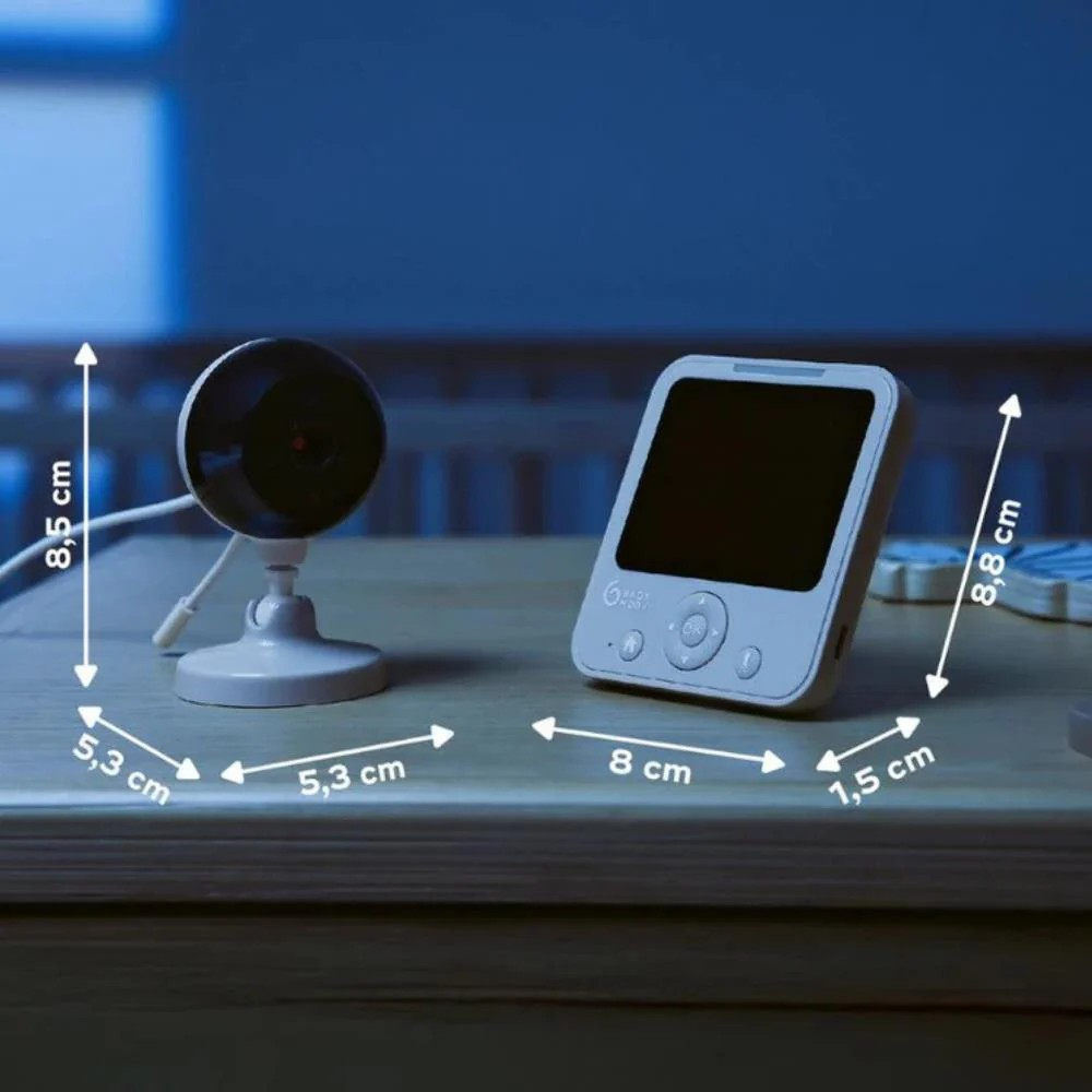 Câmara de vigilância com monitor digital branco sobre mesa de madeira