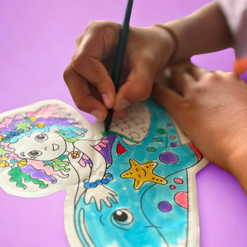 Criança a pintar desenho de sereia com lápis azul