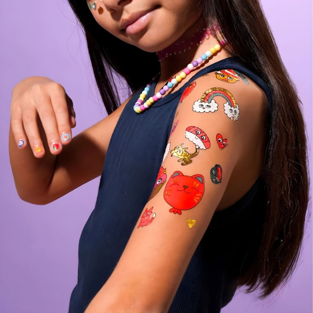 Braço com tatuagens temporárias coloridas variadas e unhas decoradas