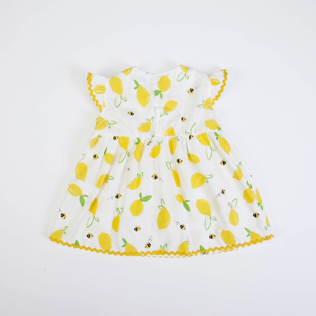 Vestido de bebé branco com estampa de limões amarelos e abelhas