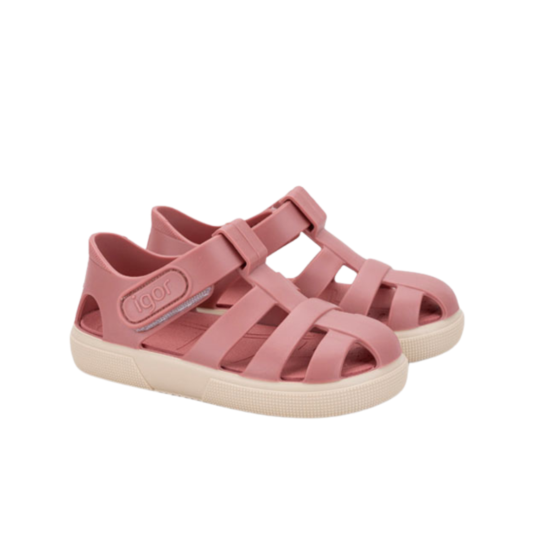 Sandálias de plástico cor de rosa com sola branca e fecho de velcro.