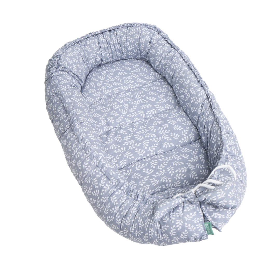 Ninho para bebé azul com padrão branco de folhas e bordas almofadadas