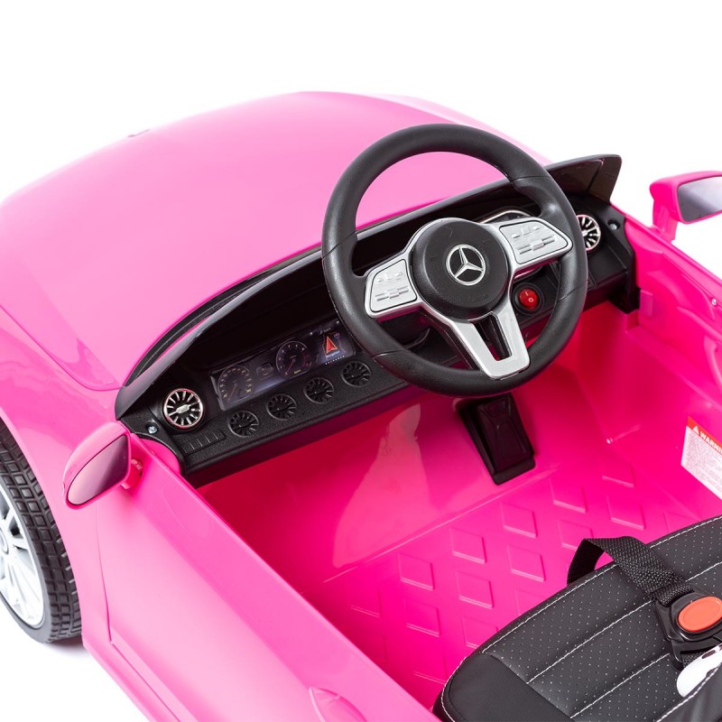 Carro de brincar cor-de-rosa com interior preto e rosa e volante com logo Mercedes-Benz