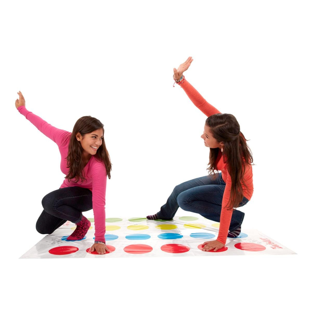 Duas raparigas jogam Twister com círculos coloridos num tapete de plástico.