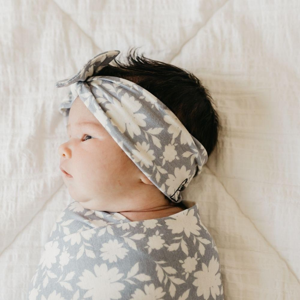 Bebé com faixa e manta florais de azul claro e branco