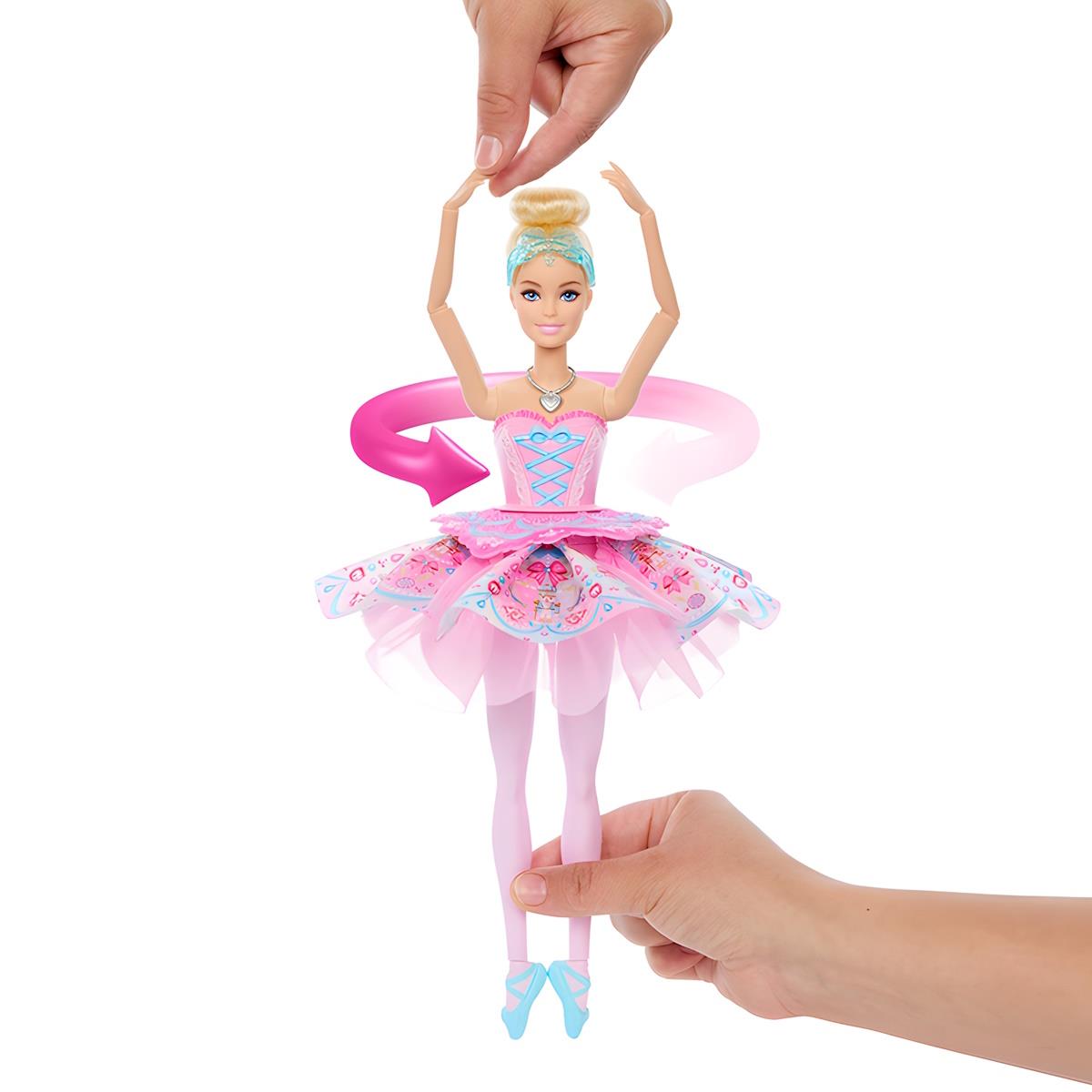 Boneca bailarina rosa com tutu colorido e sapatilhas azuis segurada por duas mãos numa pose de dança.