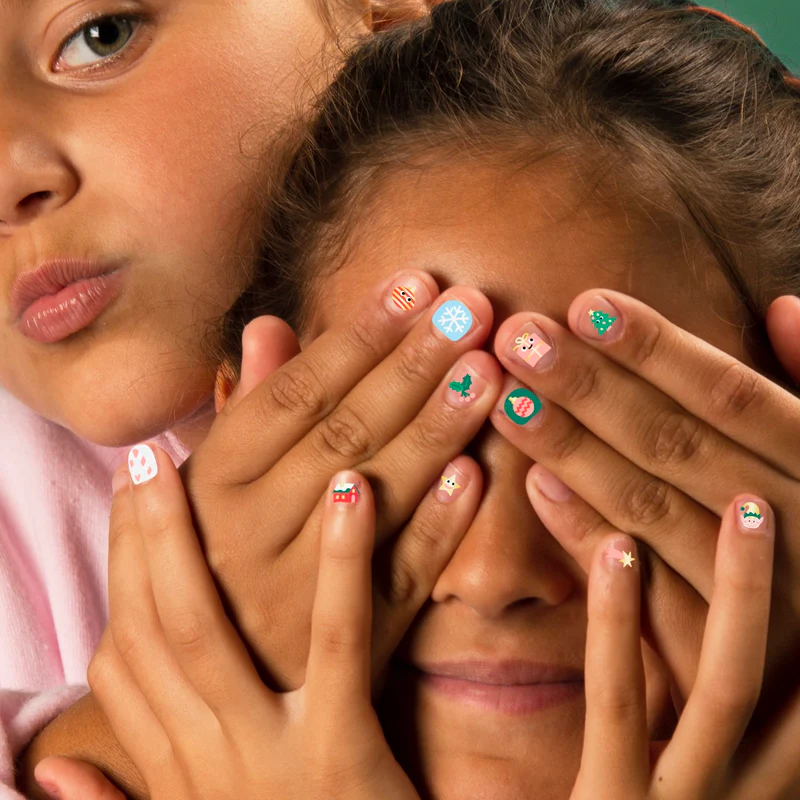 Unhas decoradas com adesivos natalícios coloridos em pele morena
