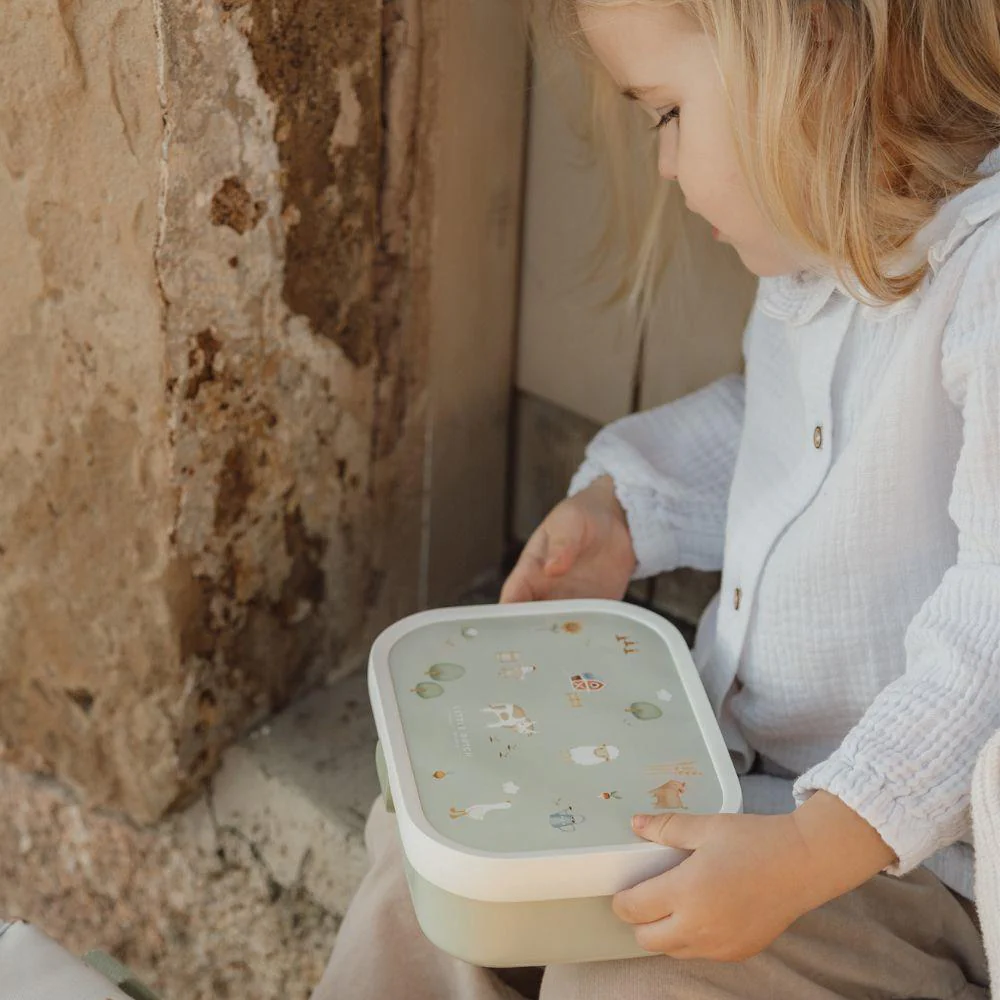 Criança com caixa de plástico decorada sentada perto de parede rústica