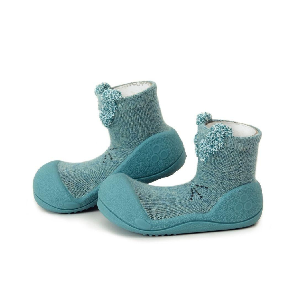 Sapatilhas infantis azuladas com biqueira e sola em borracha, parte superior em malha com textura e detalhe peludo.