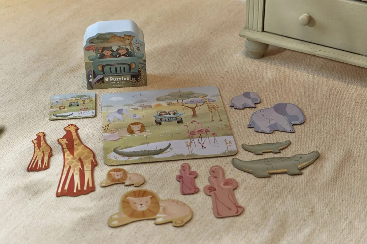 Conjunto de puzzles infantis com tema safari e animais coloridos sobre um tapete