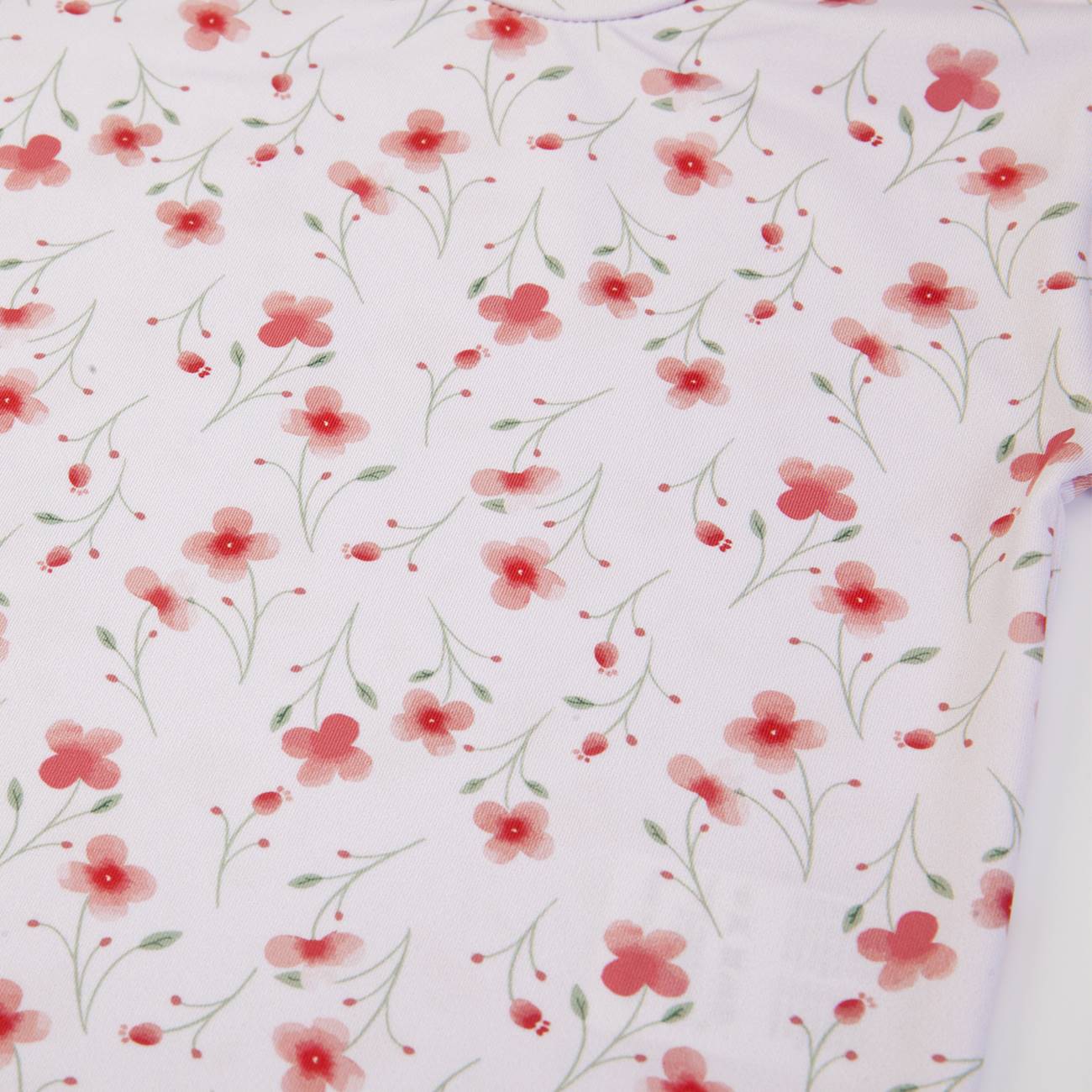 Tecido branco com flores vermelhas e folhas verdes