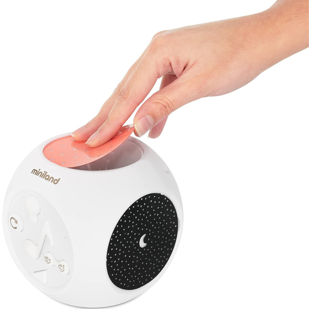 Produto eletrônico branco em forma de cubo arredondado da marca Miniland com etiqueta cor de laranja no topo