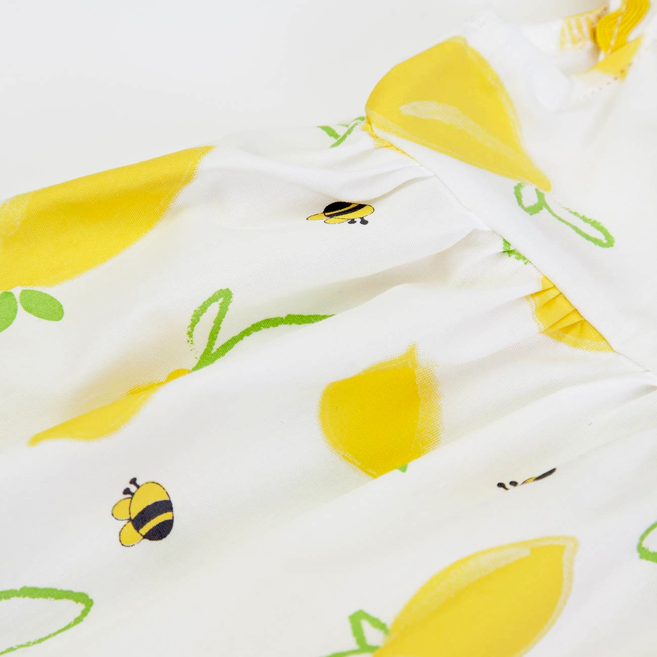 Tecido com estampa de limões, folhas e abelhas em fundo branco