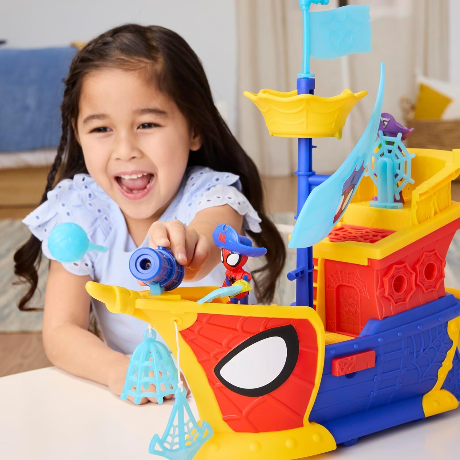 Criança brincando com navio pirata de brinquedo colorido e personagem Spiderman