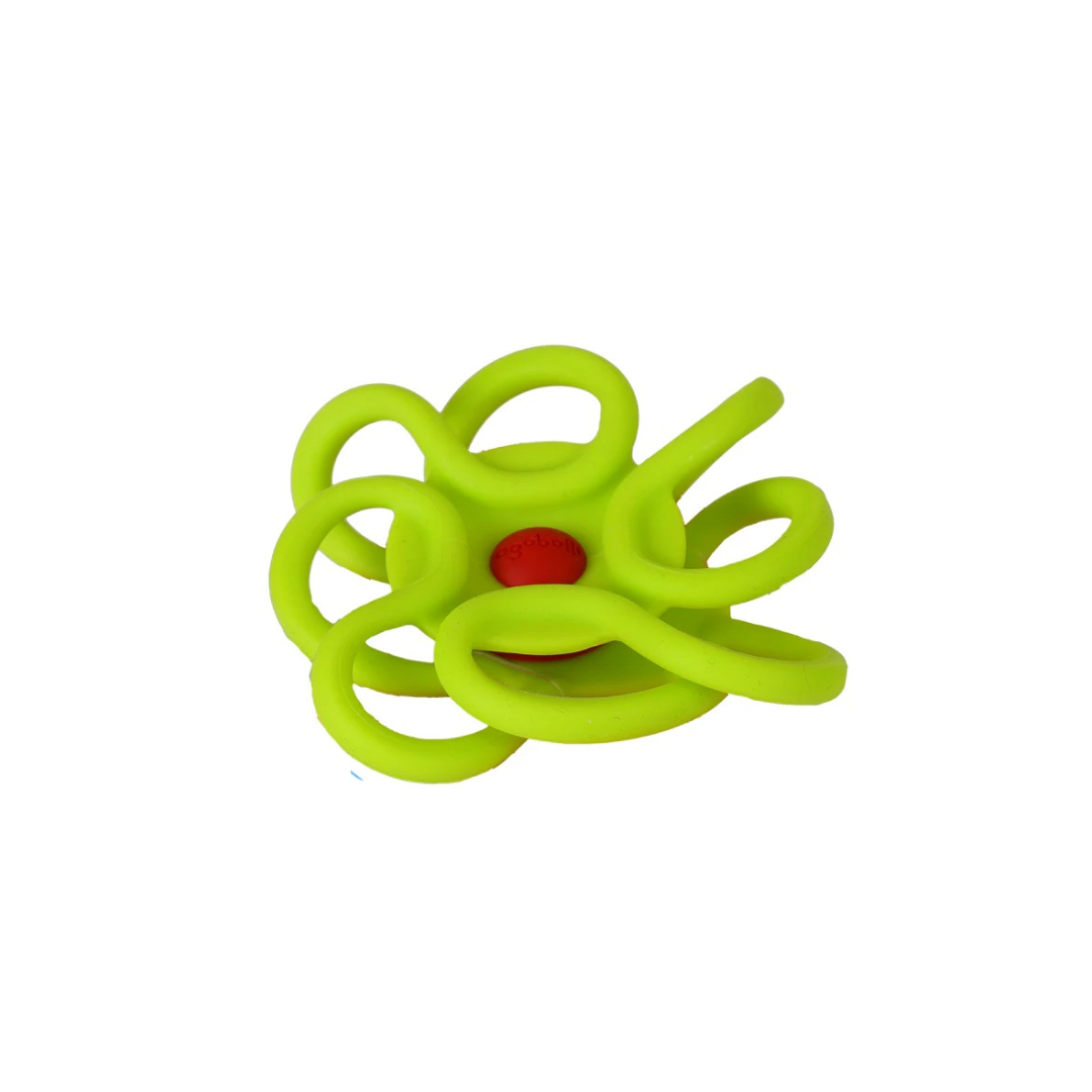 Objeto de silicone verde com várias alças circulares e base vermelha.