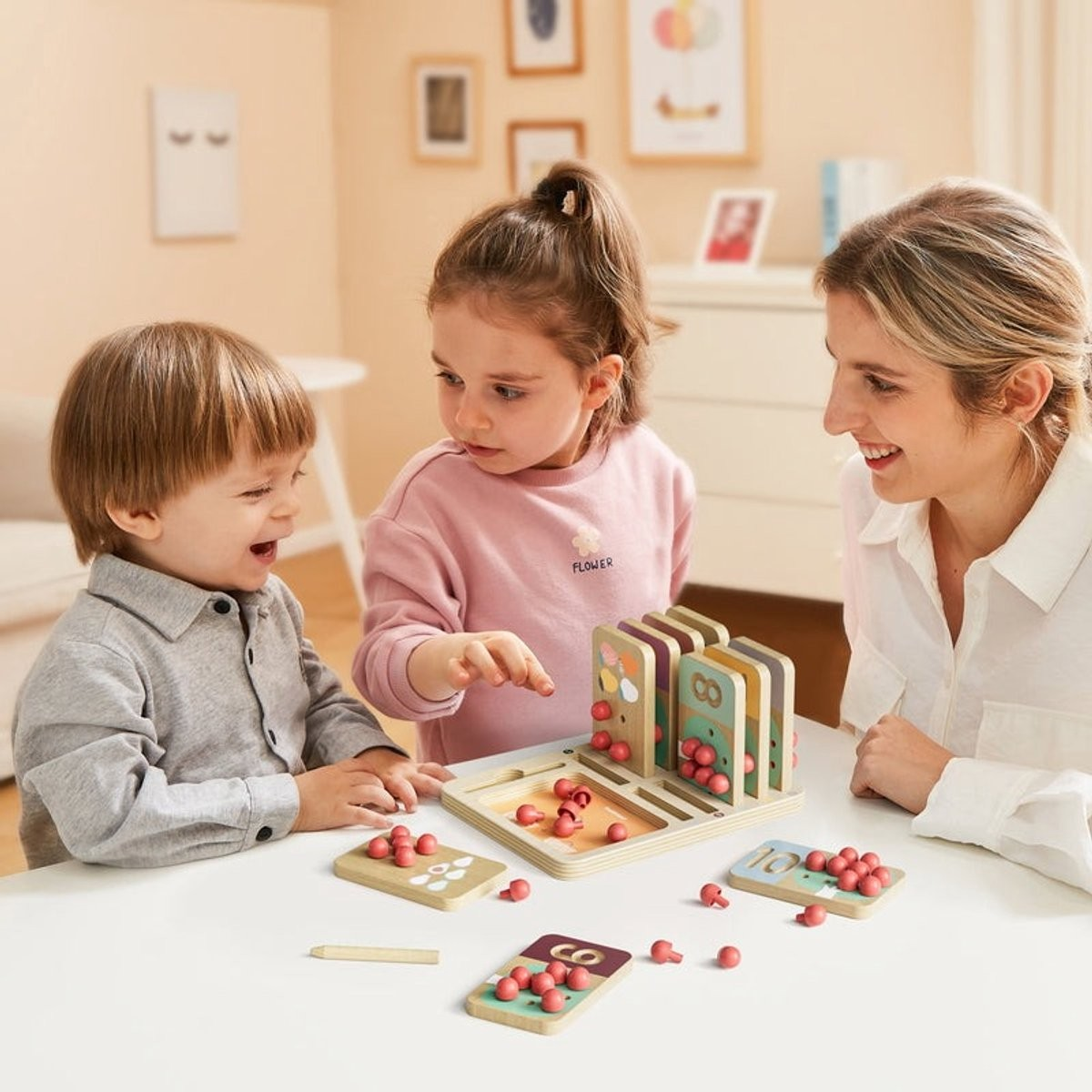 Jogo educativo de madeira com peças cor de rosa e cartões numéricos em mesa branca com crianças e mulher