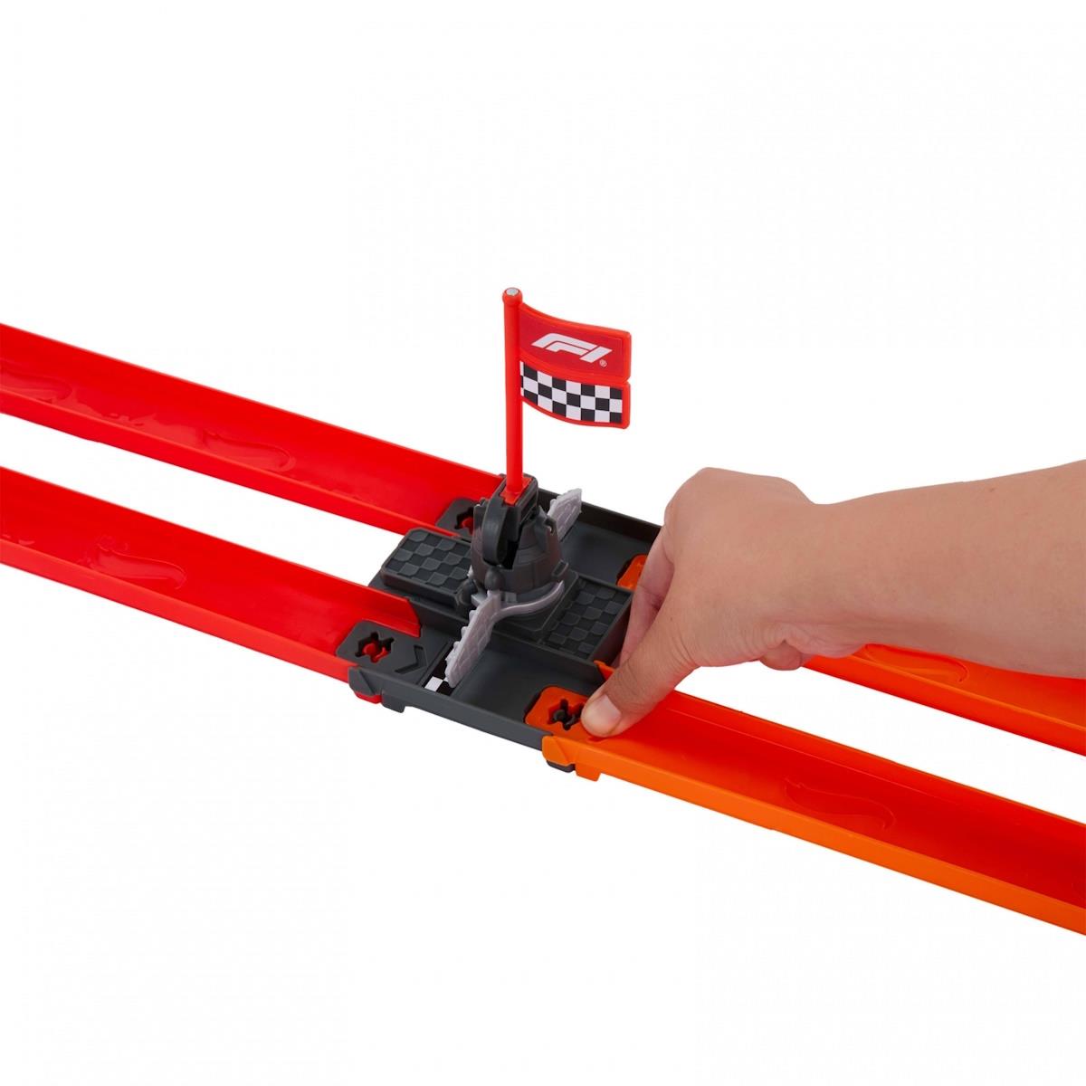Pista de corrida de brinquedo vermelha e laranja com bandeira F1 e braço a mexer