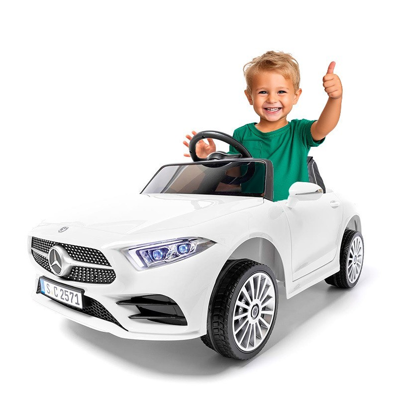 Criança feliz num carro elétrico infantil branco Mercedes-Benz